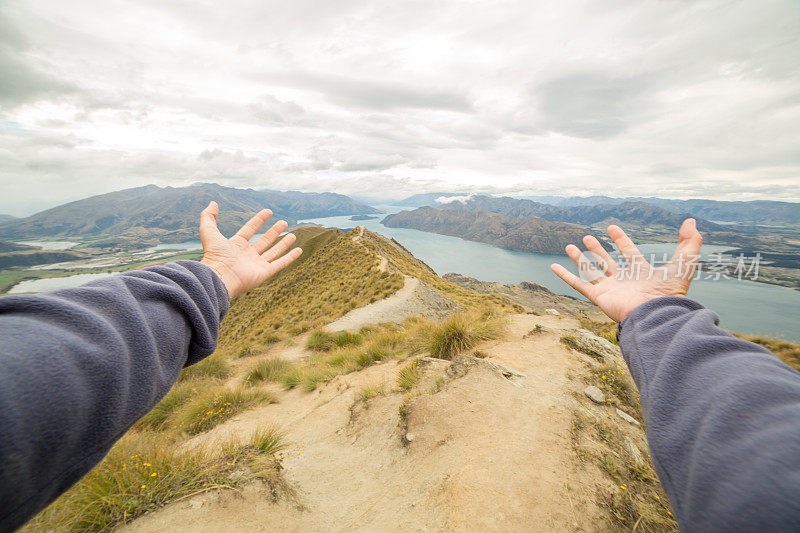 女性的手臂伸向山和湖景观