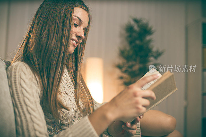 年轻女子在沙发上看书