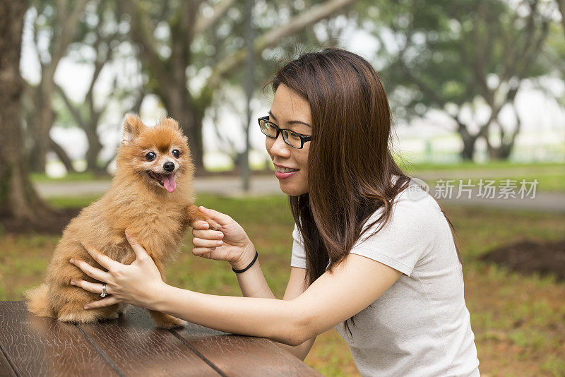 快乐的亚洲女人和博美犬