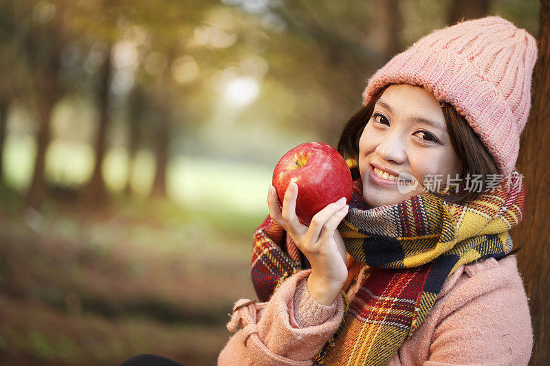 快乐的年轻女子正在吃苹果