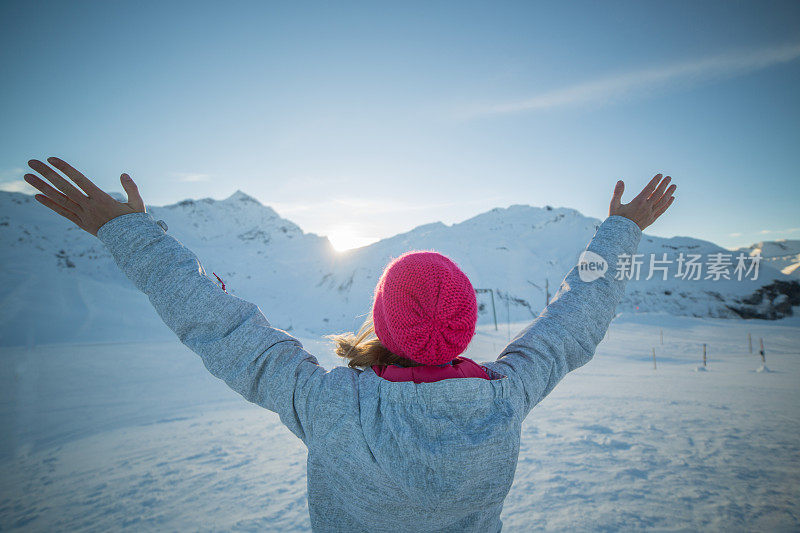 冬天，在山巅，女人为成功和自由举起双臂