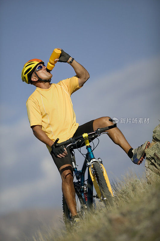 骑自行车的人用水瓶喝水
