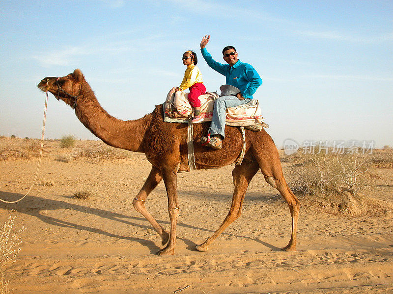 印度拉贾斯坦邦塔尔沙漠上骑骆驼的游客