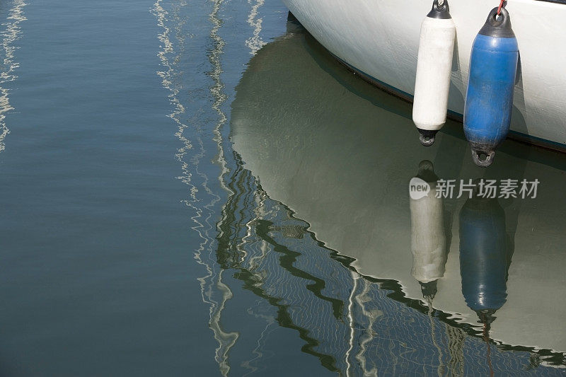 两个帆船浮标和它在水中的倒影