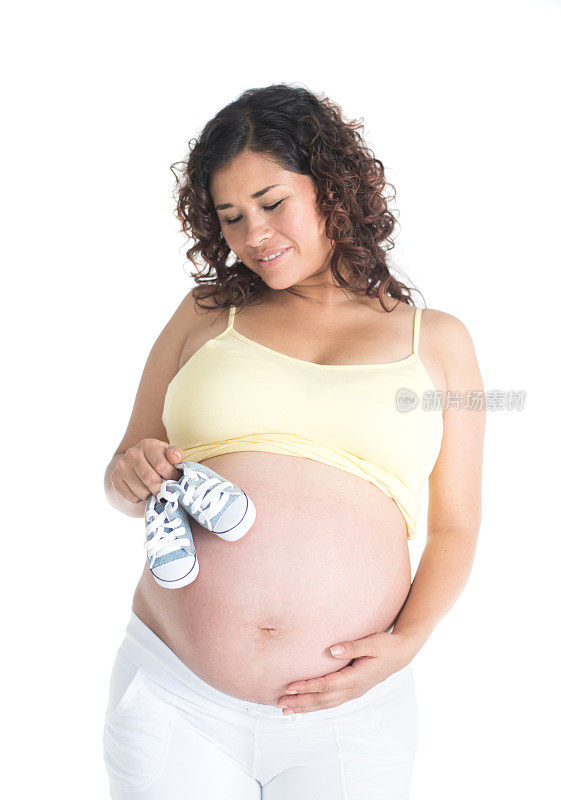 孕妇把婴儿鞋放在肚子上