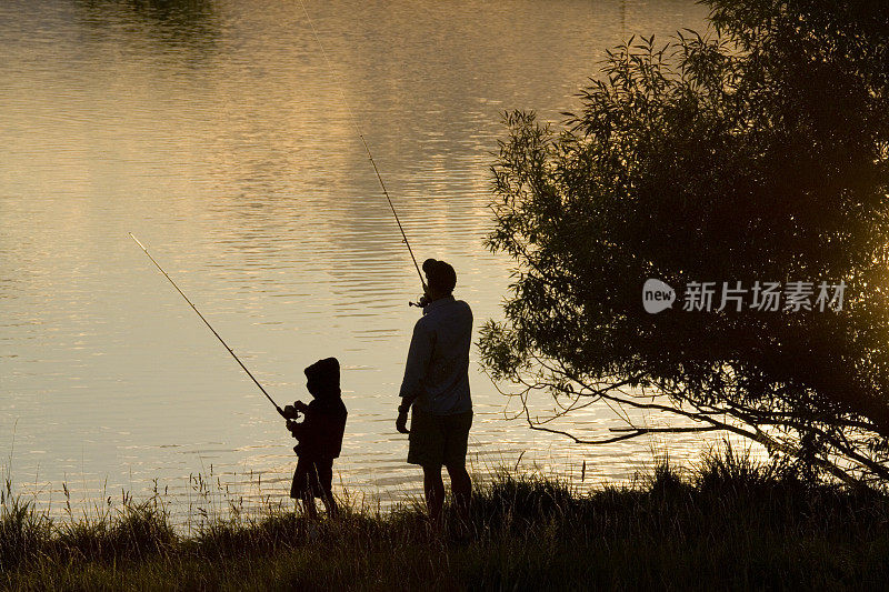 父子在湖边钓鱼的剪影