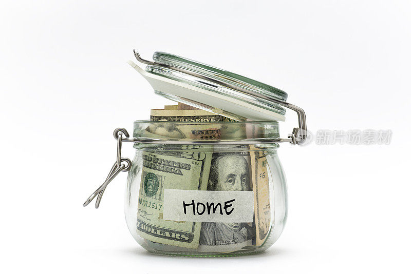 在白色背景上孤立的玻璃罐中的美元。为家里存钱。