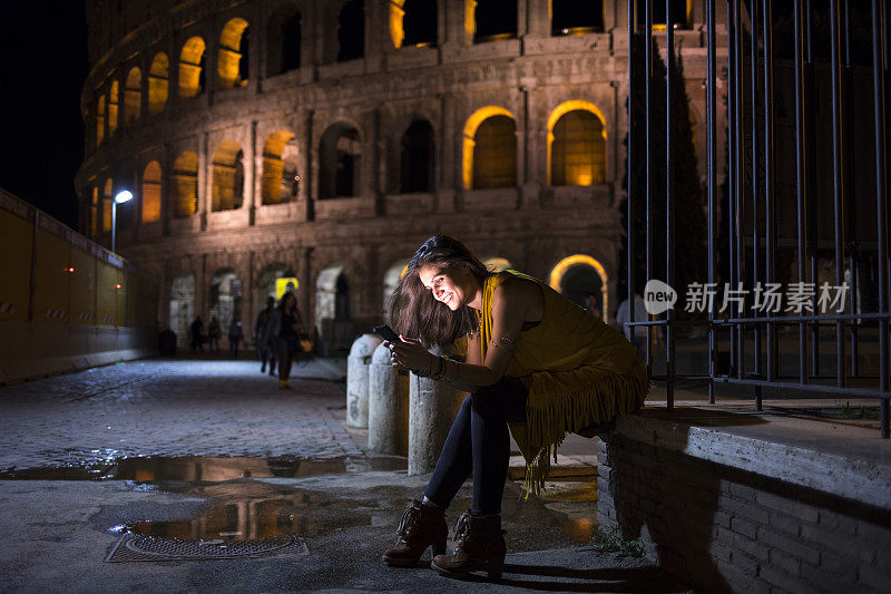 一个年轻女子在意大利的晚上进行社交网络