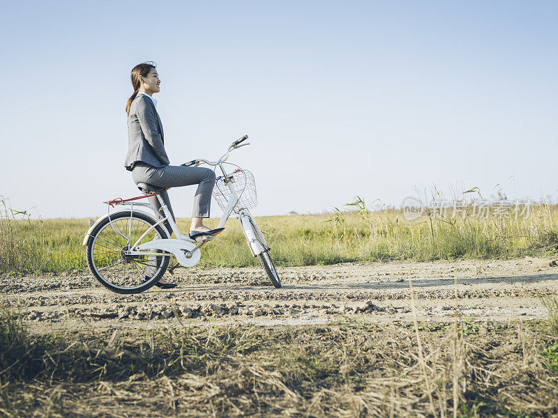 一个年轻的女商人坐在乡下的bicyale上的肖像