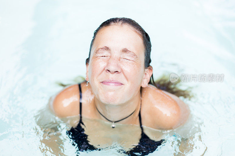 一个年轻美丽的女人从水池中浮出水面