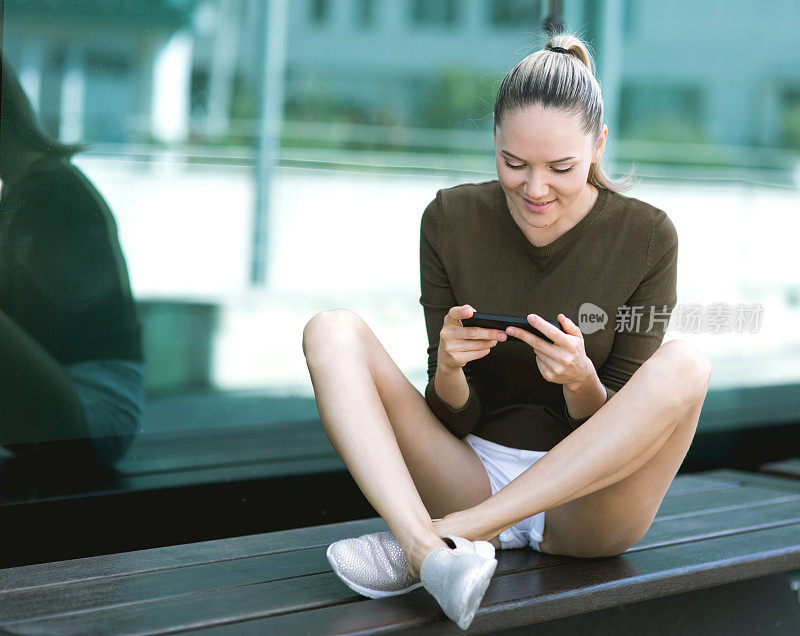 美丽的年轻女子在现实生活中使用智能手机