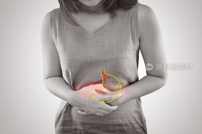 患有胃食管反流病或胃酸反流的女性站在灰色背景下，女性解剖学概念