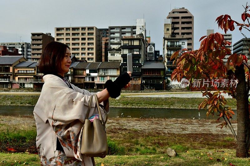 穿着和服的日本妇女在京都加茂河岸自拍