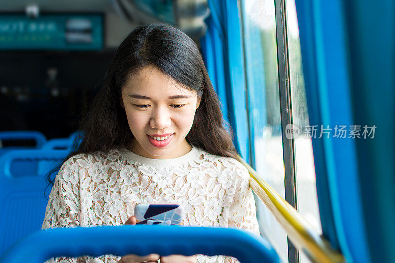 在公共汽车上用手机的女孩