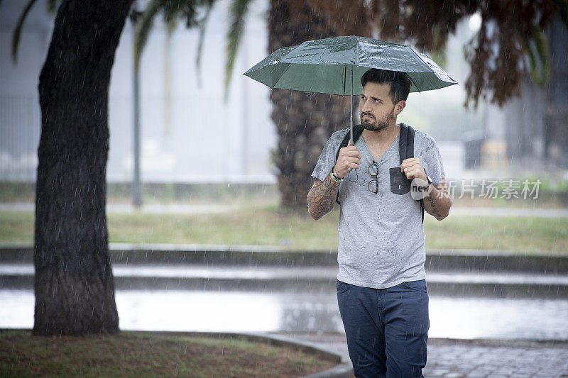 年轻的成年人在雨中行走