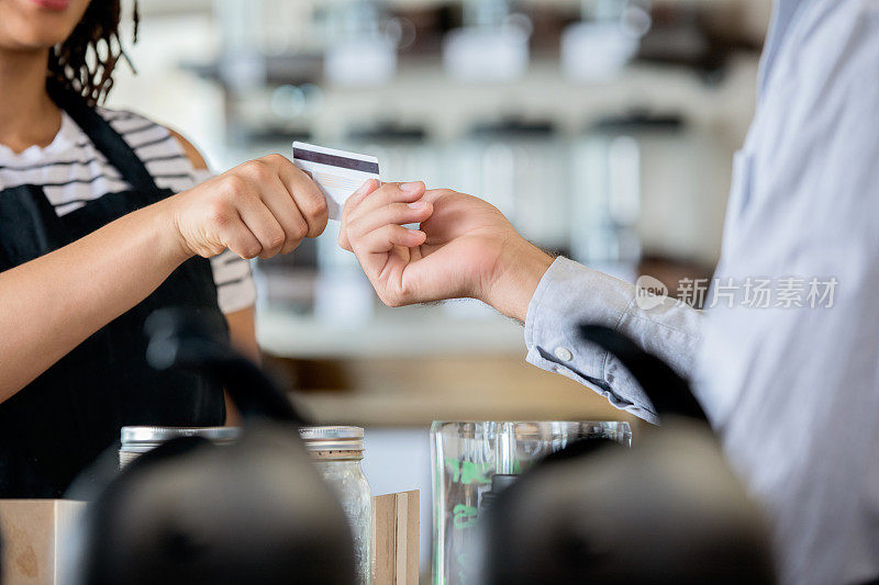 不认识的顾客用信用卡给咖啡师付咖啡钱