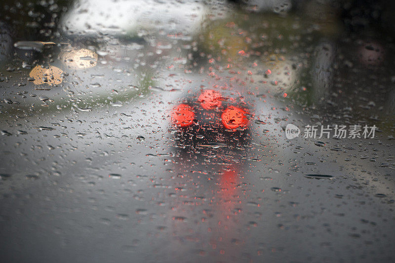 下着雨的马路，透过挡风玻璃看，车水马龙