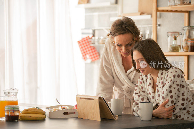 母亲和女儿在吃早餐时使用药片