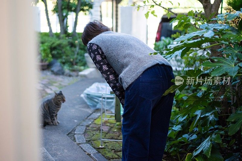老女人在花园里和她的猫