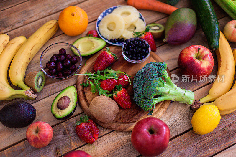 木桌上各种各样的水果和蔬菜，从上方拍摄