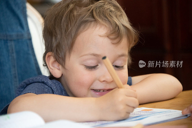 一个三岁的男孩正在做作业