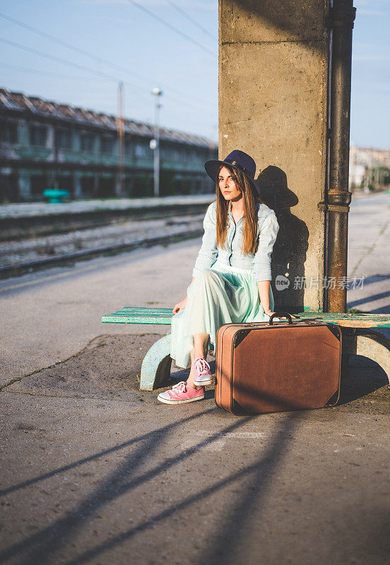 坐在长椅上等火车的女人