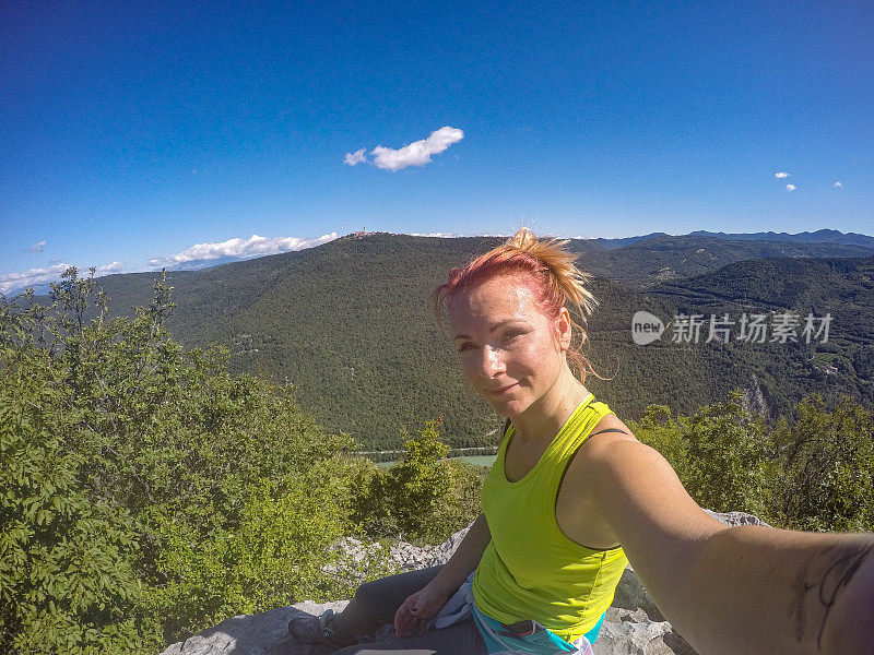 登上山顶后的年轻女子在自拍