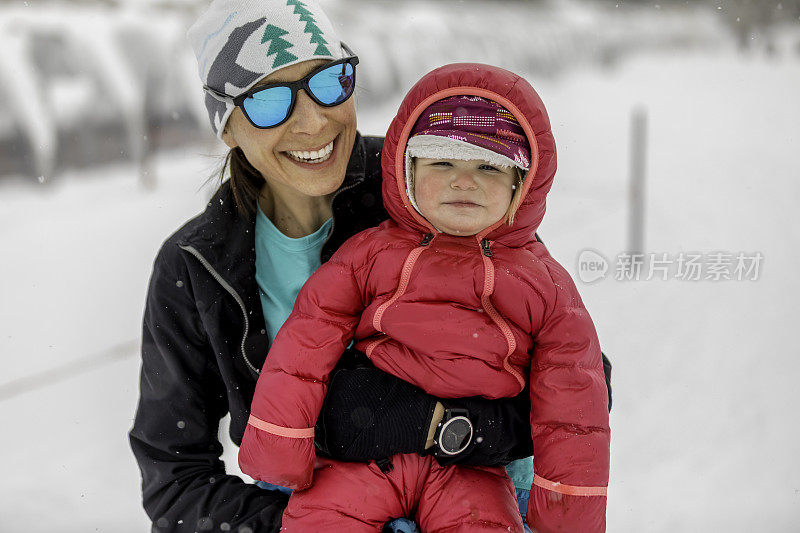 母亲和婴儿女儿滑雪