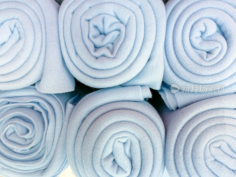 许多人把蓝色的彩色羊毛毯子卷起来放在店里，家居舒适的概念