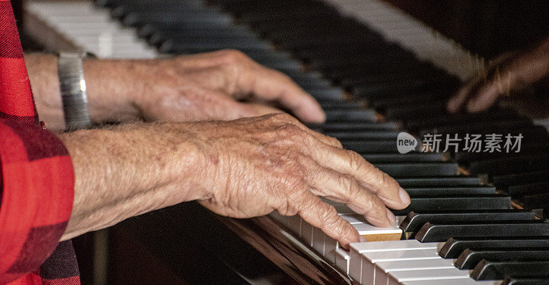 老人的手在弹钢琴。
