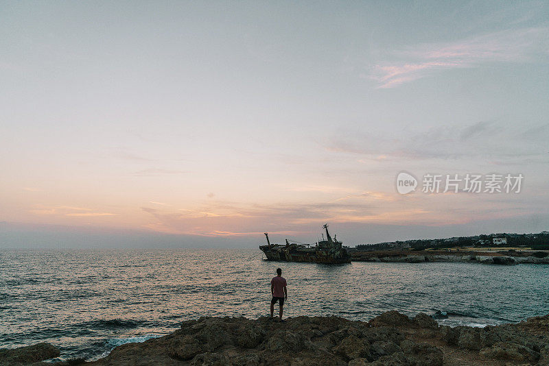 人们看着海边的风景和塞浦路斯的沉船