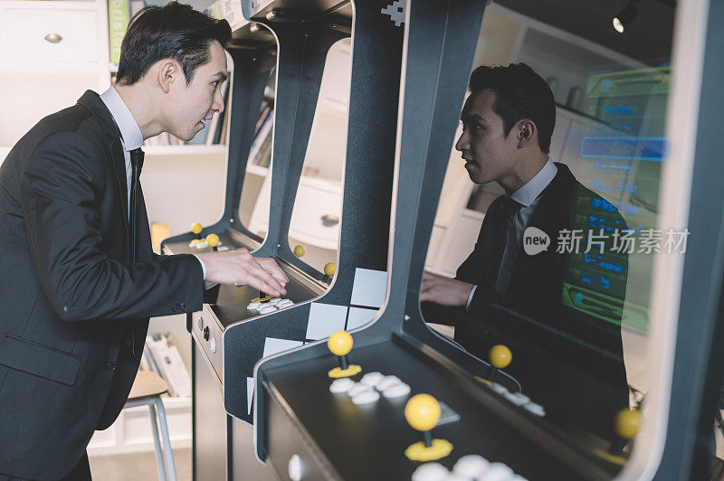 一个亚洲的中国年轻白领在他的咖啡休息时间玩电子游戏