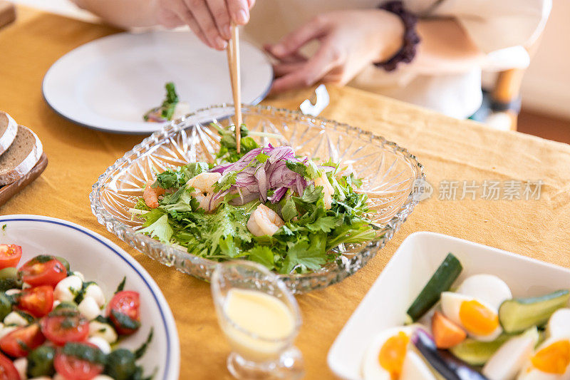 在家庭午餐派对上买沙拉达的女人