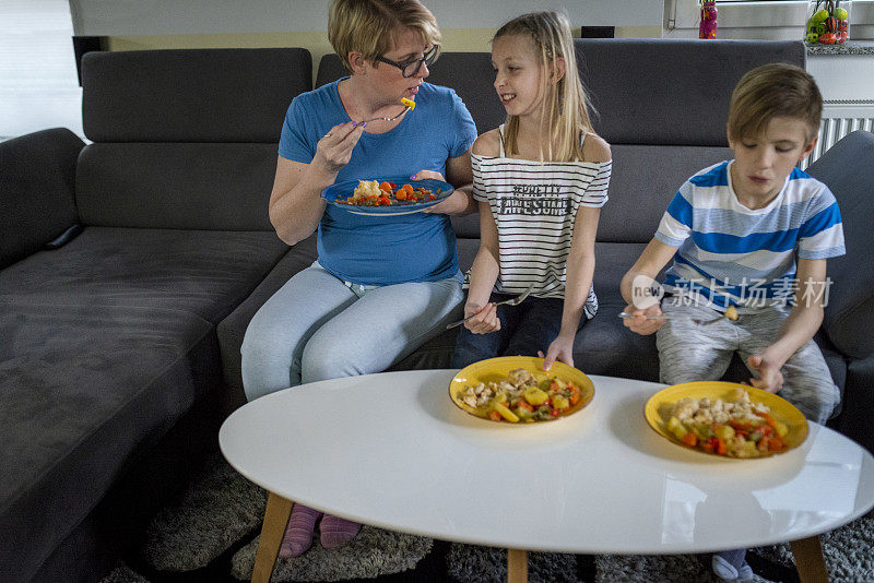 母亲和她的孩子们在客厅享受健康午餐