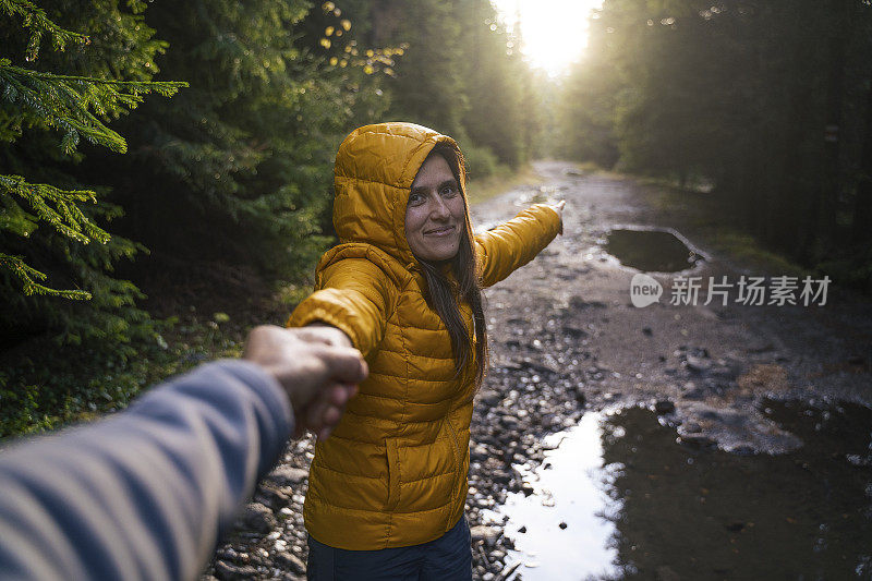 跟我来。回归自然。一对旅行者在树林里散步。一个快乐的年轻女游客漫步在大自然中。阳光明媚的日子里在森林里的户外享受。