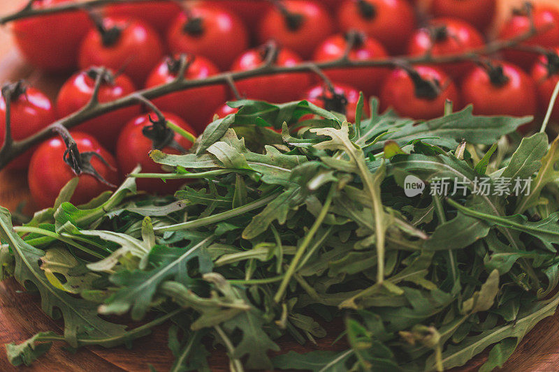 木盘上的樱桃番茄和芝麻菜，特写