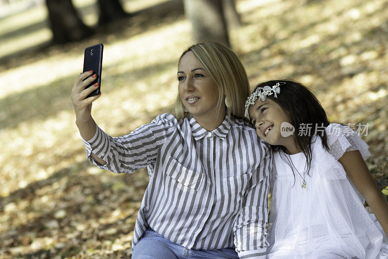 一位女士正在秋季公园和她的女儿自拍