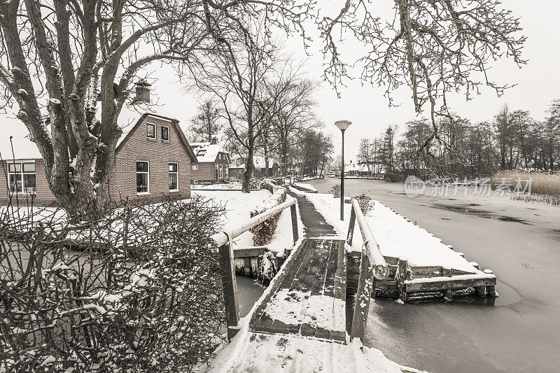 在一个寒冷但美丽而平静的冬天，Giethoorn村附近的Dwarsgracht有积雪的运河