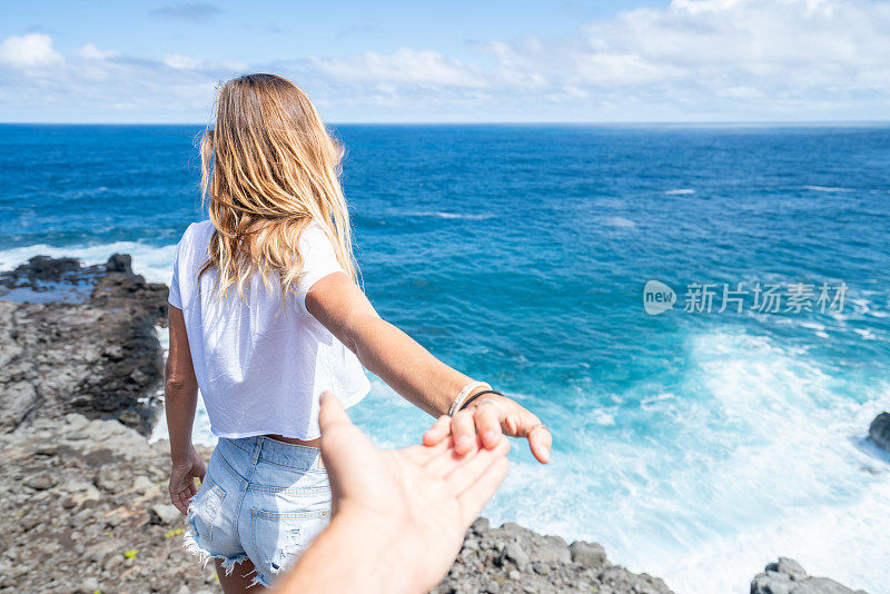 跟随我的概念-年轻的女人带领男朋友到悬崖上的海