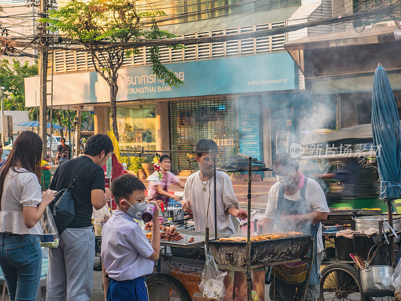 街上的食物车与不熟悉的泰国人在曼谷城市街道上。泰国