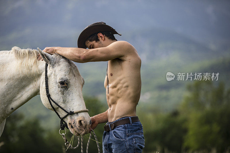 赤膊青年男子与他的白马在自然界