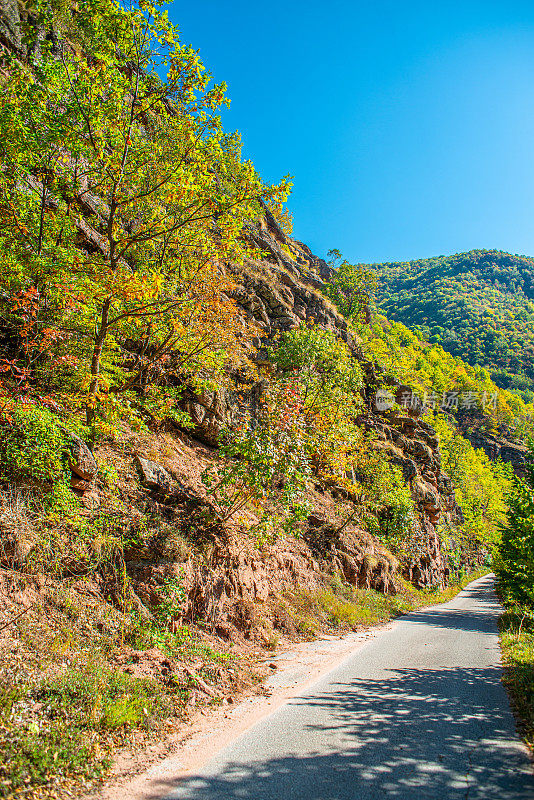 柏油路，山石景观，阳光灿烂的天空