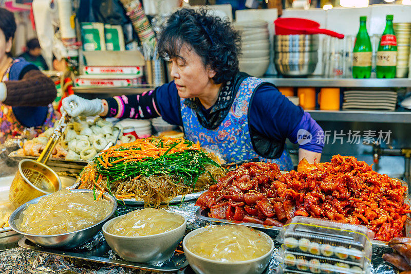 在首尔的光江市场，一名卖主在为顾客服务