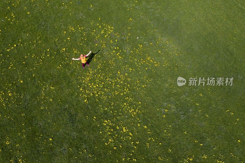 在春天的草地上，女人张开双臂，腾空而起