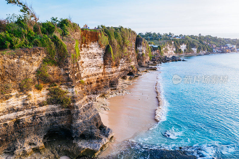 Uluwatu巴厘岛。蓝色的海洋和岩石山，覆盖着热带树木。