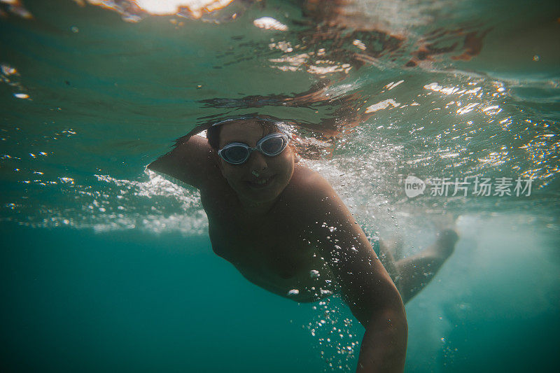 一个十几岁的男孩在海水里潜水