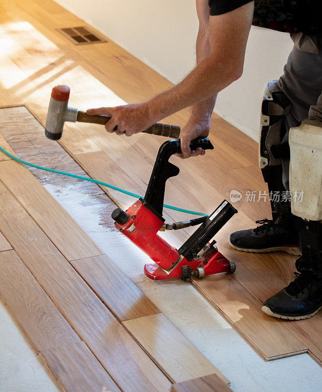 木地板安装与气动
钉枪在家里。