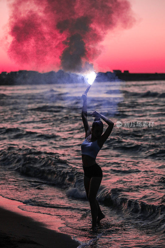 自由女子在沙滩上点燃火炬冥想