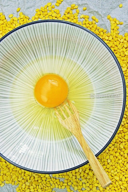 蛋清和蛋黄碗-黄色绿豆背景。