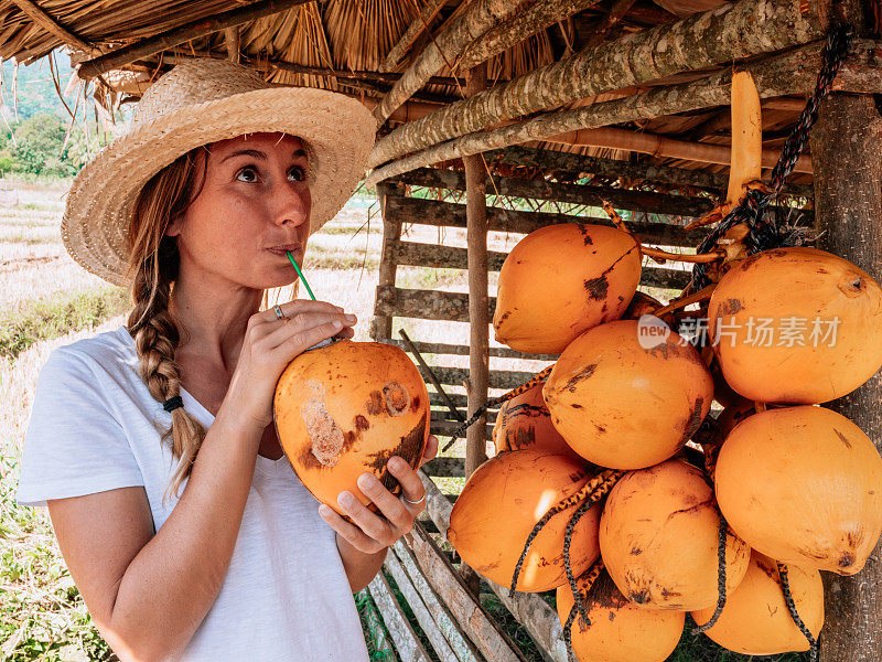 一个女人在街边卖椰子